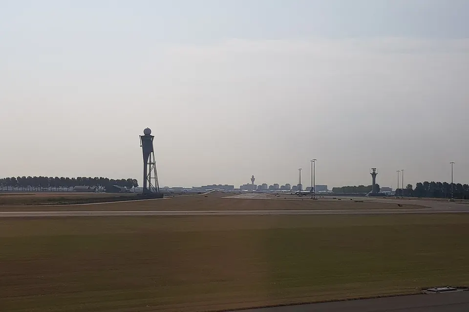 Akkers in de polder met in de verte de verkeerstoren van Schiphol
